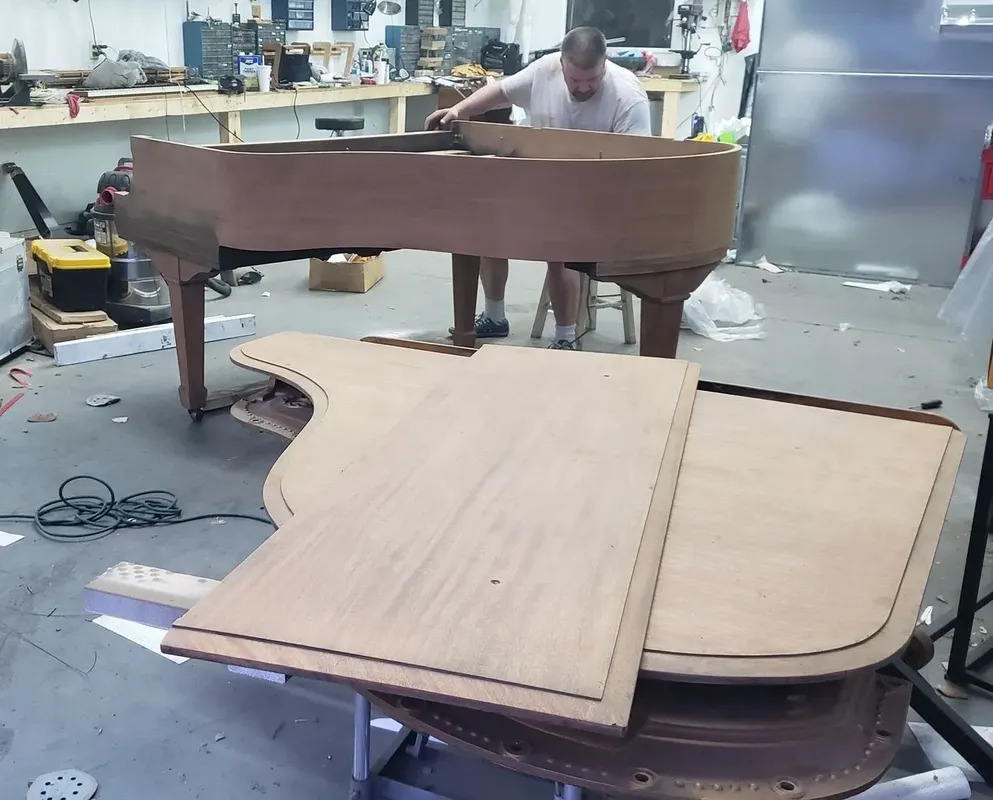 Stripping and sanding a grand piano in the St. Louis Pianoworks shop.